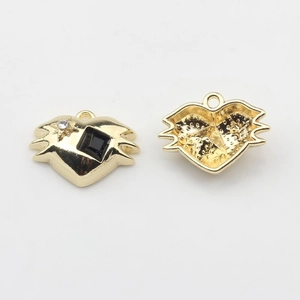 Detail of gold heart pendant with bat wings featuring black gemstone and star crystals