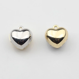 Polished double-sided heart charms in silver and gold plating for DIY jewelry making