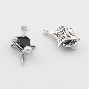 Detalle de colgante de estrella plateada con corazón negro y perlas blancas