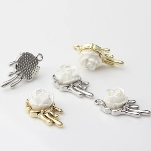 Macro view of rose pendant charm with liquid metal base and pearl texture finish