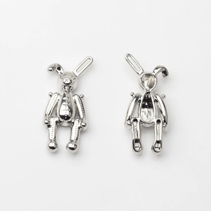 Vue détaillée des pendentifs lapin montrant textures mécaniques et dos creux
