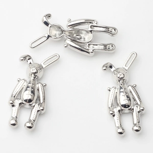 Détails macro de trois pendentifs lapin mecha argentés avec finition polie et textures