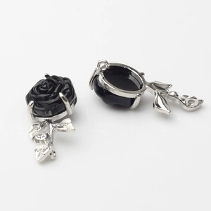 Macro view of black 3D rose charms with silver plating and crystal accents