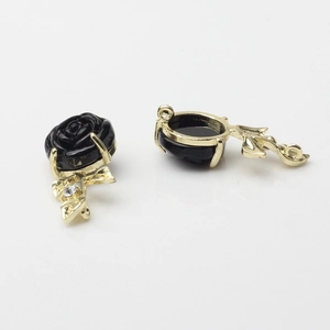 Detailed view of 3D black rose pendant with gold metal frame and sparkling crystal leaf