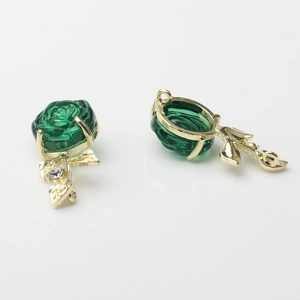 Macro shot of 3D rose pendant featuring translucent green petals and gold metal leaf with rhinestone