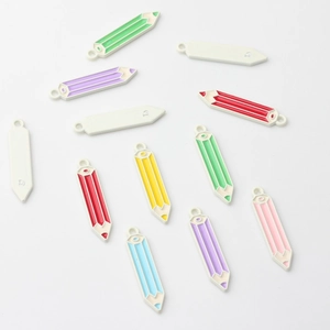 Macro detail of colorful enamel pencil charms for jewelry making with hanging loops