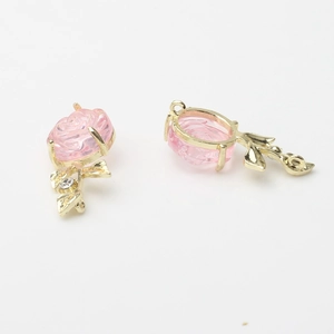 Detailed macro of pink resin rose pendant with gold alloy base and zircon leaf for DIY