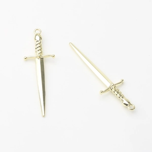 Macro detail of polished gold-plated alloy long sword pendants for DIY jewelry making