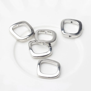 Macro shot of five polished silver square hollow beads for DIY jewelry making