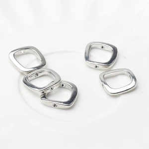 Close-up of five silver square alloy beads with side holes for DIY jewelry making