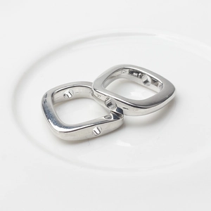 Close-up of polished silver alloy square charms with side holes for DIY jewelry making