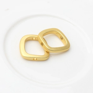 Close-up of golden square matte beads with side holes for DIY jewelry making