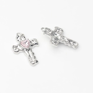 Detail van zilveren kruishanger met roze hart zirkoon en honingraat achterkant