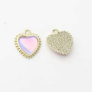 Detail view of heart-shaped gold-plated charms with pink zircon inlay for DIY jewelry