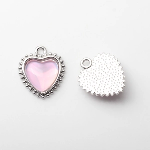 Detail of silver beaded heart pendant with iridescent pink stone for DIY jewelry making