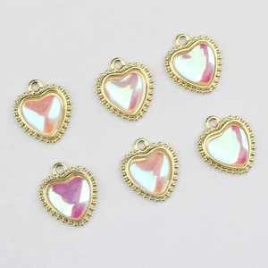Macro detail of six gold-plated heart charms with iridescent zircon inlay for DIY jewelry