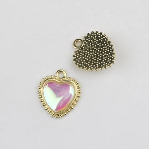 Macro view of gold-plated heart charms with pink aurora zircon for DIY jewelry