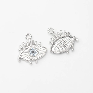 Macro detail of silver evil eye pendant with blue zircon and textured honeycomb back