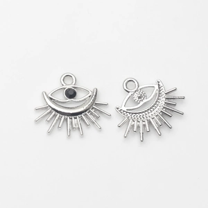 Detail of silver alloy evil eye charms with black stone inlay and ray patterns