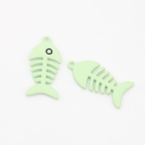 Macro detail of two light mint green fish bone pendants with a matte finish for DIY jewelry