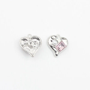 Detail of heart-shaped DIY pendant components with pink zircon and white pearl inlay