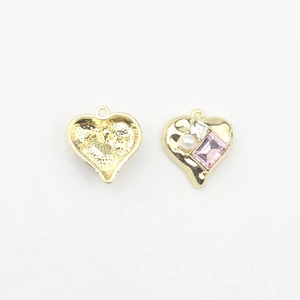 Macro view of heart-shaped gold pendants with inlaid pearls and pink crystals