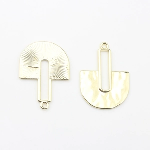 Detail of gold geometric hollow charms with radial sunburst and hammered metal textures