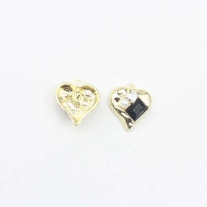 Detailed macro view of heart-shaped gold jewelry pendants with pearl and zircon inlay