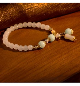 Primer plano de pulsera de cuentas de calcedonia natural con borla sobre madera