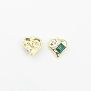 Detailed view of heart-shaped gold pendant with emerald-cut green stone and white pearl