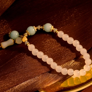 Elegante pulsera de piedras naturales con colgante de bambú sobre seda oscura
