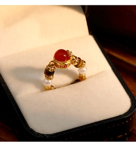 Detailed view of beaded ring with red agate, tiger eye stones and pearls in a gift box