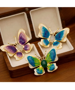 Macro shot of three butterfly brooches with enamel gradient wings and rhinestone edges