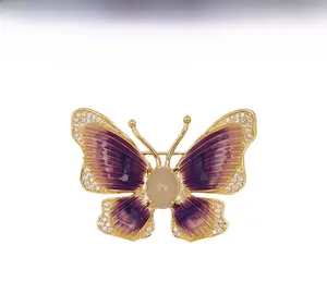 Macro shot of butterfly brooch with purple enamel wings and sparkling zircon details