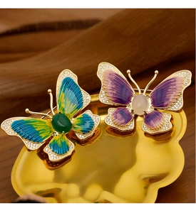 Detailed macro view of enamel butterfly brooches with gradient colors and micro-pave crystals