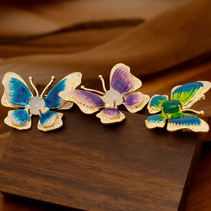 Luxury enamel butterfly brooches set with zircon and gemstones on a wooden base