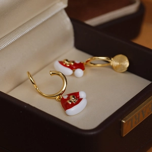 Orecchini natalizi con ciondolo a cappello in smalto rosso in una scatola regalo di lusso