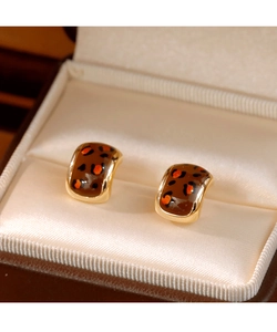 Détails de boucles d'oreilles vintage léopard carrées avec bords dorés sur soie