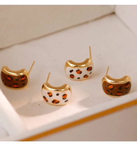 Gros plan sur des boucles d'oreilles léopard en forme de C, marron et crème