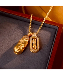 Macro shot of gold Pixiu and Vajra pendants with sparkling white crystals on a chain