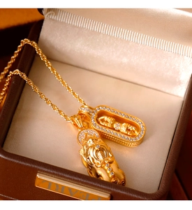 Detail of matte gold Pixiu and Buddha pendant necklace with sparkling white crystals