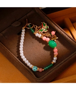 Detaillierte Nahaufnahme des Perlenarmbands mit Schmetterlingsanhänger und goldenem OT-Verschluss