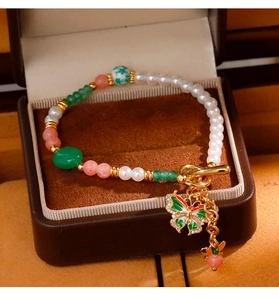 Detailansicht Perlenarmband mit grünem Emaille-Schmetterling und goldenem OT-Verschluss