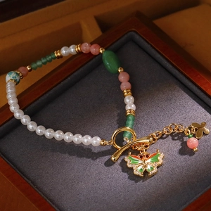 Elegantes Perlenarmband mit Emaille-Schmetterling und bunten Perlen in einer Samtbox