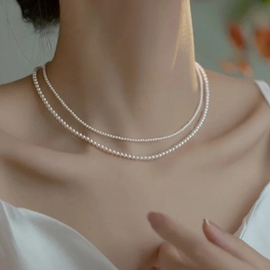 Elegant double-layered minimalist 2mm pearl necklace worn by a model on neck