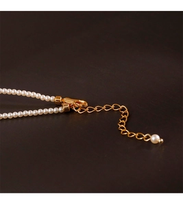 Close-up of 2mm round white pearls with a golden lobster clasp and adjustable extender chain