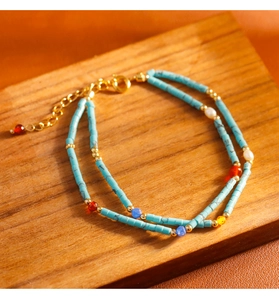 Detalle de la pulsera de doble capa de turquesa y perlas con herrajes de metal dorado