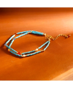 Detalle de pulsera de doble capa de turquesa y perlas con cierre dorado