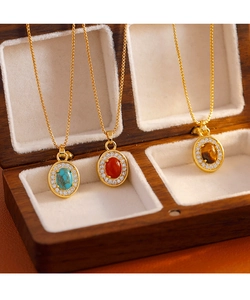 Vue détaillée de colliers dorés avec pendentifs en turquoise, agate rouge et oeil de tigre