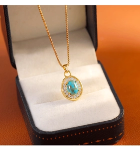 Vue détaillée du pendentif vintage ovale en turquoise et cristaux sur une chaîne dorée